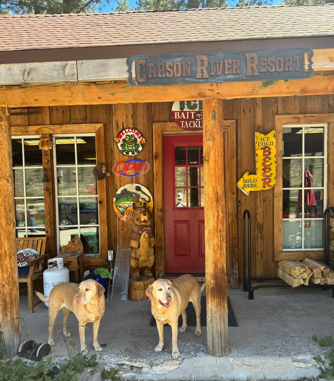Carson and River holding the store porch between the carved bear and the beer sign.