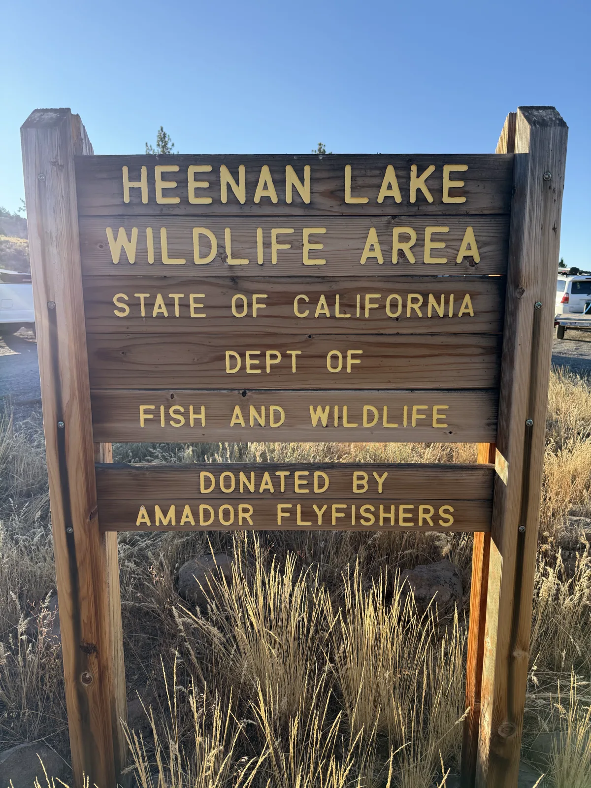 The entrance sign — State of California, Dept of Fish and Wildlife, donated by the Amador Flyfishers — anglers' rigs parked behind.