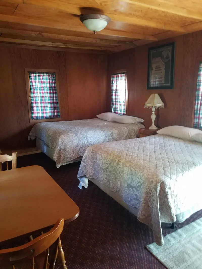 The bedroom — The room from the table — two beds under the windows, the dining table in the foreground.