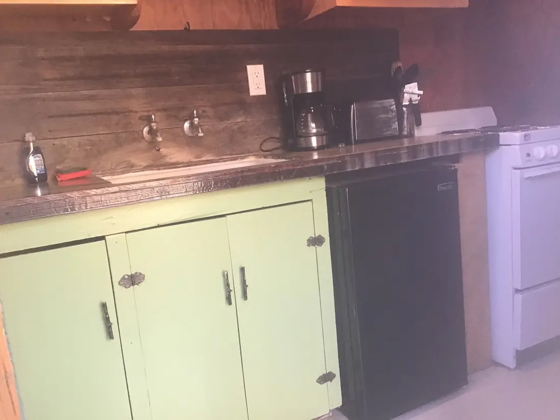 The kitchen — The counter run — coffee maker and toaster, refrigerator and range, cupboards underneath.