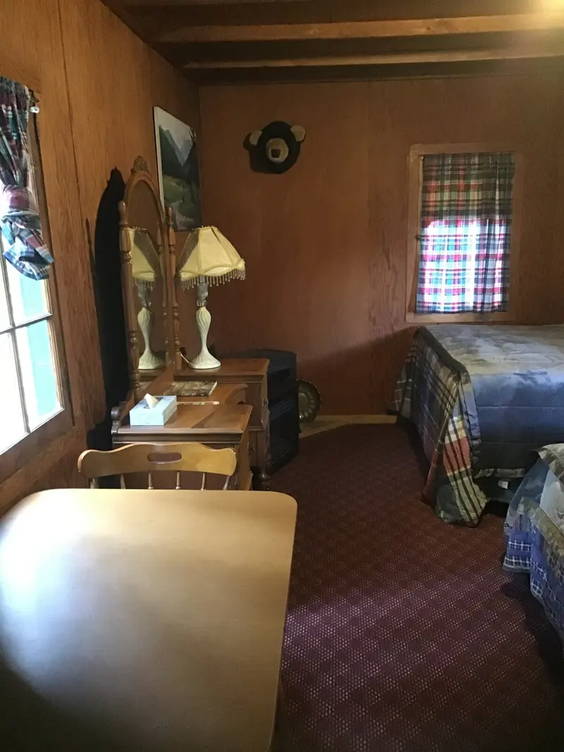 The sitting area — The sitting corner — a mirrored vanity with twin lamps, a table and chairs, the bed beyond.