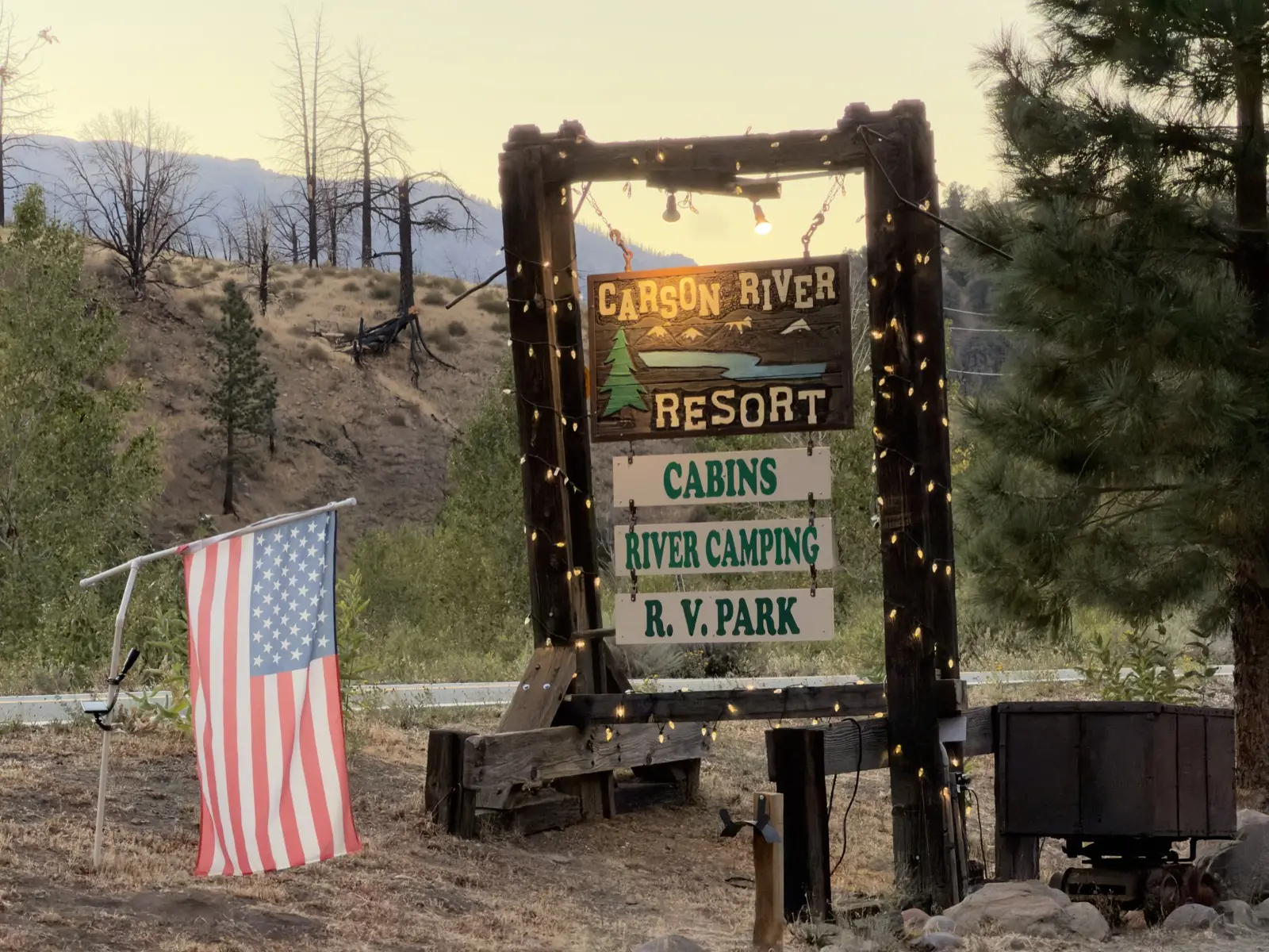 The sign on Highway 89 at dusk — cabins, river camping, R.V. park.