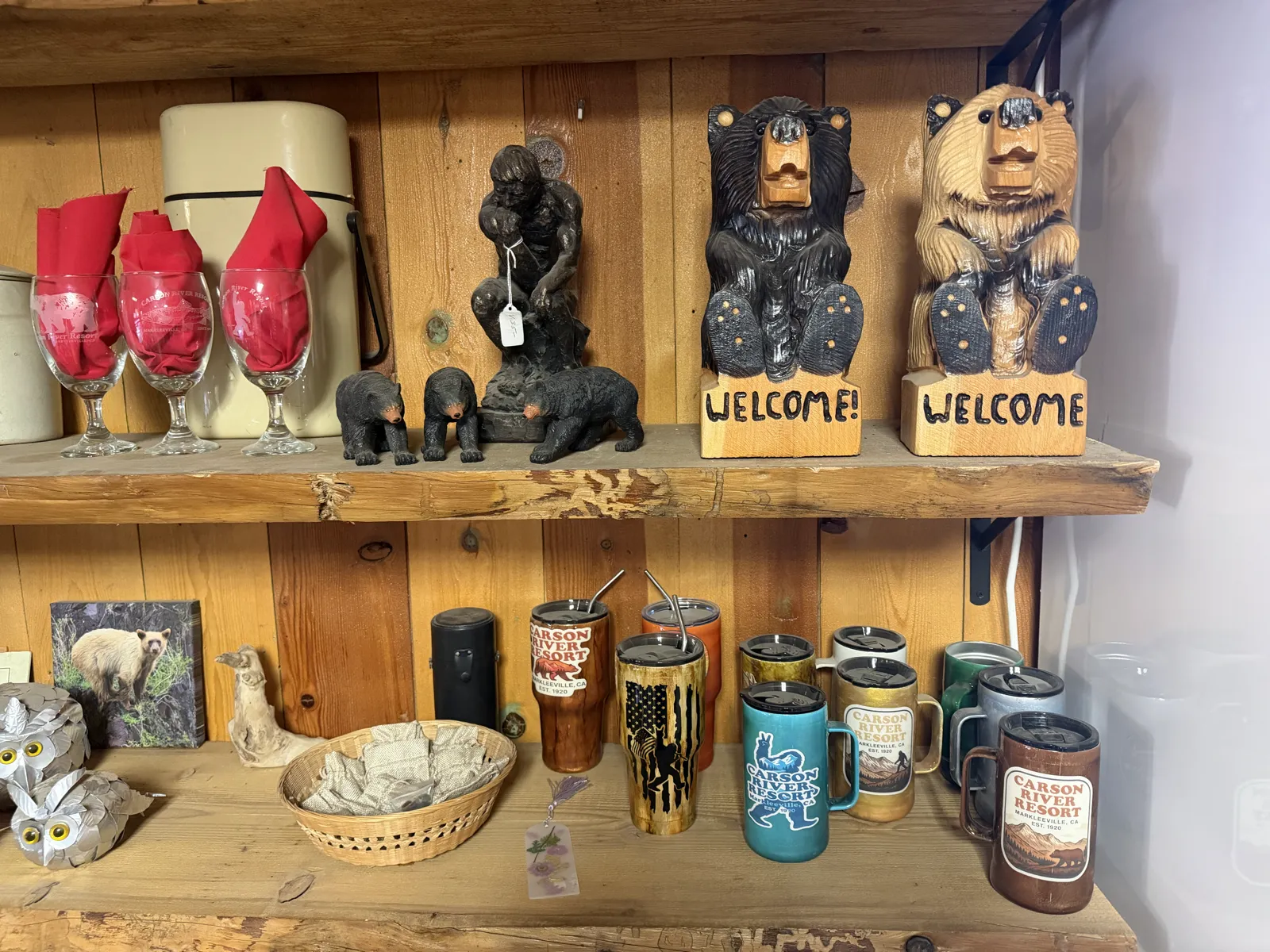 The legend, merchandised — the sasquatch tumbler on the store's gift shelf, between the carved welcome bears.